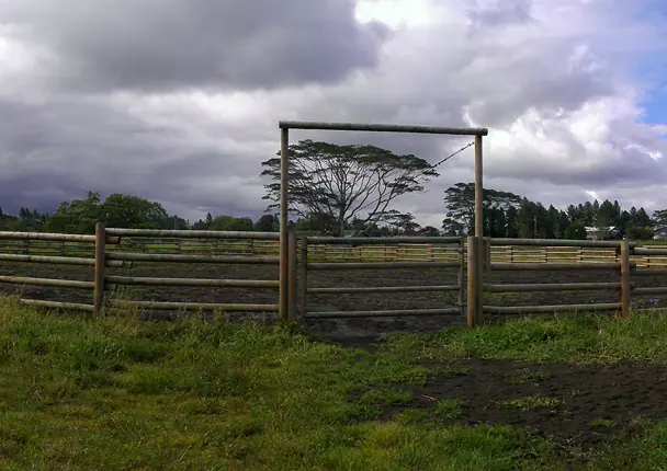 Wooden ranch corral and gate under a cloudy sky in Keaau